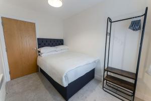 een kleine slaapkamer met een bed en een houten deur bij ALTIDO Modern flats in central Birmingham, next to business district in Birmingham