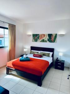 una camera da letto con un grande letto con una coperta rossa di Spacious Apartment @MeliaTortugaResort a Prainha