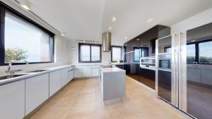 a kitchen with white cabinets and large windows at SEE AND SEA in Barrika
