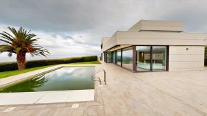 uma casa com piscina e uma palmeira em SEE AND SEA em Barrika