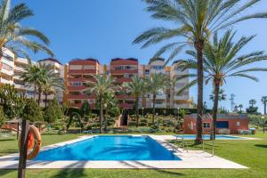 een uitzicht op het resort met palmbomen en een zwembad bij Apartamento de diseño 2 terrazas en Estepona by Rent Me in Estepona