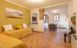 a room with two beds and a dining room with a table at Agriturismo Le Crete - Appartamenti in Asciano