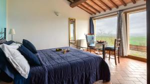 a bedroom with a bed and a table and chairs at Agriturismo Le Crete - Appartamenti in Asciano