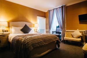 a hotel room with a bed and a chair at The George Hotel in Inveraray +109 photos