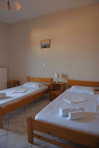 two beds in a room with two tables at Nikos Studios in Gialiskari