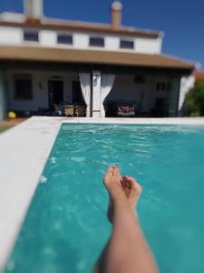 una persona sdraiata sul bordo di una piscina di Vivienda rural La Monería a Las Delgadas