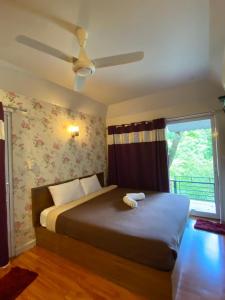 a bedroom with a bed with a ceiling fan at The Triple M Mountain Resort in Ban Muang Ton Mamuang