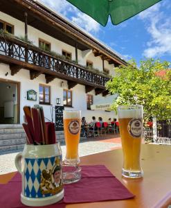 Kastanienhof Pfettrach في التدورف: كأسين من البيرة يجلسون على طاولة
