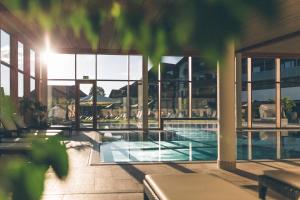 a building with a swimming pool and a building with windows at Hotel Eibl-Brunner 4-Sterne-Superior in Frauenau