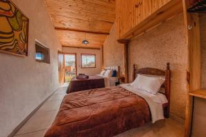 two beds in a room with wooden ceilings at Vila Espinhaço in Diamantina