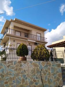 a house with a stone wall in front of it at Kate House in Agioi Apostoli