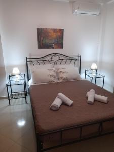 een slaapkamer met een bed met twee handdoeken erop bij Kate House in Áyioi Apóstoloi