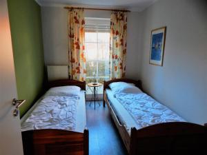 two beds in a small room with a window at Strandoase Typ STO-A STRANDOASE Whg. SO2 in Wustrow