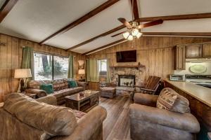 sala de estar con muebles de cuero y chimenea en Pet Friendly Grizzly Blair Lodge Cabin, en Groveland