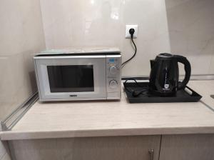 a microwave sitting on top of a counter with a coffee maker at Nikos house studios in Ofrínion