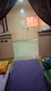 Zimmer mit einem lila Teppich und einem Zimmer mit einer Tür in der Unterkunft DAKHLA in Ad-Dakhla