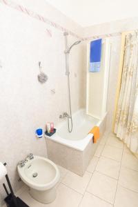 a bathroom with a bath tub and a toilet at Relax al mare, appartamento Gelsomino in San Vincenzo