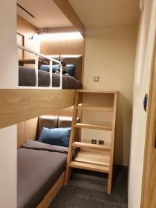 ドバイにあるsleep 'n fly Sleep Lounge, B-Gates Terminal 3 - TRANSIT ONLYの小さなお部屋で、二段ベッド2組、はしごが備わります。
