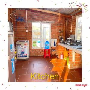 a kitchen with a brick wall and a refrigerator at Ty Phu Miet Vuon Homestay - Entire Bungalow in Tây Ninh