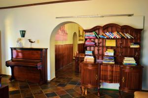 a room with two wooden bookshelves and a piano at Central Hotel Omaruru in Omaruru