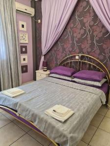 a bedroom with a bed with purple sheets and purple pillows at Άνετο, μεγάλο σπίτι κοντά στο μετρό in Piraeus