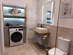 łazienka z pralką i umywalką w obiekcie Castle Apartman **** w mieście Sátoraljaújhely +17 zdjęć