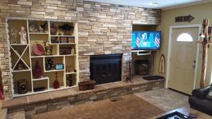 a living room with a stone fireplace and a tv at Claim Jumper 9 Townhouse With High Speed Wifi in Red River