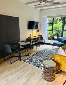 ein Wohnzimmer mit einer Couch und einem Tisch und Stühlen in der Unterkunft Sunset Kloof in Wilderness