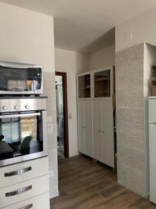 a kitchen with a stove and a microwave at Lake Apartment Ischia Red, Lago di Caldonazzo in Tenna 