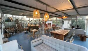 a living room with a couch and tables and chairs at Brisas del Paraná, casas de campo, Cafe, Spa & Río in San Pedro