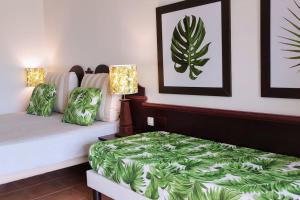a bedroom with a bed with a green comforter at Studio "Prestige" Sainte Luce in Sainte-Luce