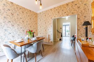 a dining room with floral wallpaper and a table and chairs at The Old Concert Hall - Norfolk Cottage Agency in Holt