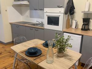 une cuisine avec une table et un vase dans l'établissement Lou Magnan, à LʼIsle-sur-la-Sorgue