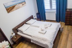 a bedroom with a bed with two towels on it at Al-Dom Apartamenty Wiśniowy Ogród z garażem in Kołobrzeg