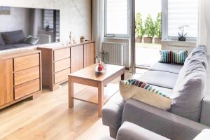 a living room with a couch and a table at Al-Dom Apartamenty Wiśniowy Ogród z garażem in Kołobrzeg