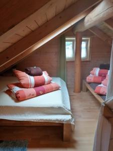 a attic room with a bed with pillows on it at Gästehaus Celine in Meuspath