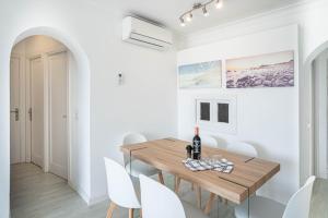 une salle à manger blanche avec une table en bois et des chaises blanches dans l'établissement CARABELA 93, à Alcúdia
