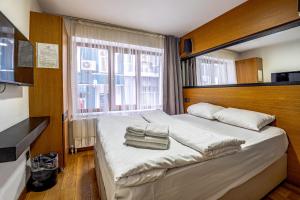 una camera da letto con un grande letto bianco con una grande finestra di Xenia Hotel Taksim a Istanbul