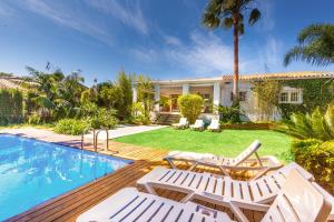 une maison avec une piscine et deux chaises longues dans l'établissement LXR Benalmadena 4 Hab. Paradise Villa, à Benalmádena