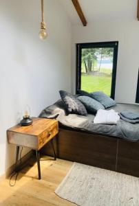 a bedroom with a bed with a table and a mirror at Siedlisko Dziki Gil na Mazurach z prywatną plażą i SPA! in Ruś
