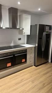 a kitchen with a stainless steel refrigerator and cabinets at Filton 6 BDR House for contractors & families. in Bristol