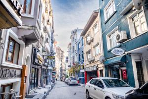 イスタンブールにあるXenia Hotel Taksimの建物のある路上に駐車した白い車