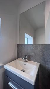 a white sink in a bathroom with a mirror at Filton 6 BDR House for contractors & families. in Bristol