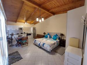 a bedroom with a bed and a table and a kitchen at Lyn's Self Catering in Swakopmund