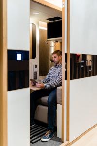 a man sitting at a table in a room at sleep 'n fly Sleep Lounge & Showers, NORTH Node - TRANSIT ONLY in Doha