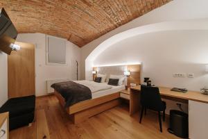 sypialnia z łóżkiem i biurkiem w pokoju w obiekcie Operna klet Ljubljana w Lublanie