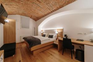 a bedroom with a bed and a desk in a room at Operna klet Ljubljana in Ljubljana