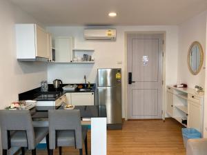 a kitchen with a table and chairs and a refrigerator at Notthing Hill Charoenkrung93 Condominium in Godown