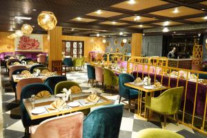 a restaurant with tables and chairs and a person in the background at Amritara Surya - A Luxury Spa Retreat in Dharamshala