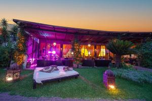 Amareclub Baia Dei Turchi Resort - Adults Only في أوترانتو: غرفة بها سرير في العشب مع أضواء